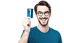 Sichern auch Sie sich eine schufafreie Kreditkarte Mann lacht und hält Prepaid Kreditkarte